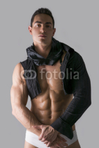 Fototapety Muscular young man with single-sleeved shirt on naked torso