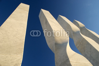Abstract white marble monument in the background of blue sky