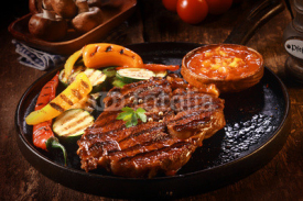 Naklejki Grilled Steak with Vegetables on Cast Iron Pan