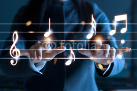 Naklejki Woman hands playing music notes on dark background, music concept