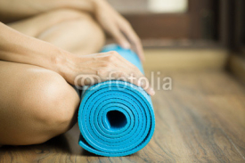 Naklejki Young woman holding a yoga mat
