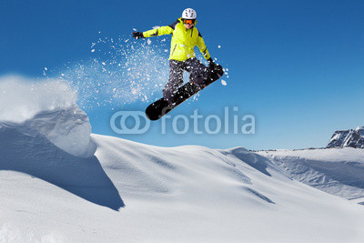 Free rider on snowboard jumping from hill