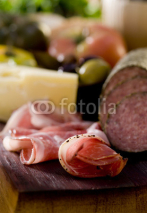 Naklejki Rustic wood platter with meat, cheese and vegetables.
