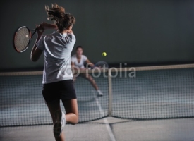 Naklejki young girls playing tennis game indoor
