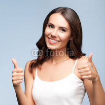 Portrait of happy woman showing thumb up gesture, on grey