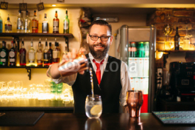 Bartender is making alcohol cocktail at counter