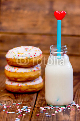 Doughnuts and  milk with heart. Focus on milk