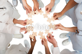 Fototapety Medical Team Holding Jigsaw Pieces In Huddle