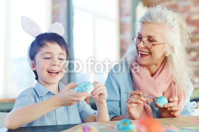 Little boy and senior female making Easter eggs for holiday