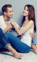 Beautiful young amorous couple, sitting on floor