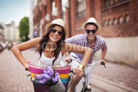 Fototapety Happy couple cycling in the city