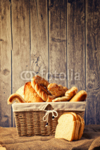 Fototapety Delicious bread and rolls inwicker basket