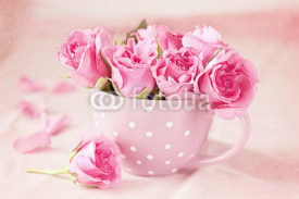 Naklejki Beautiful fresh roses in a  cup on a pink background