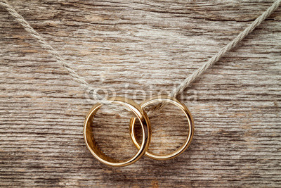 Wedding rings hanging on rope.