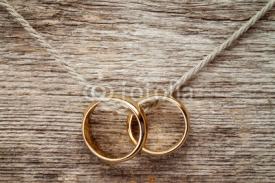 Naklejki Wedding rings hanging on rope.