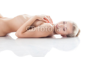 Naklejki Portrait of smiling girl lying naked in studio