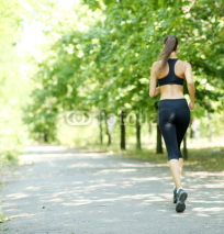Naklejki Young woman jogging at park