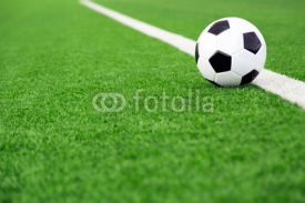 Naklejki Traditional soccer ball on soccer field