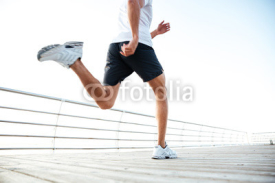 Fototapety Cropped image of athlete runner's feet and shoes running