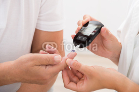 Obrazy i plakaty Doctor Using Glucometer On Patient's Finger