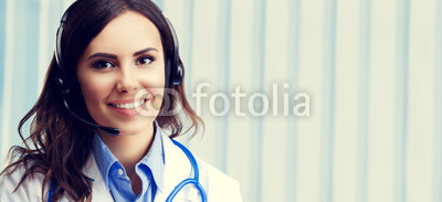 Smiling young doctor in headset, at office