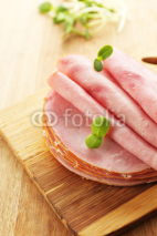 Naklejki Tasty ham with sunflower sprouts on wooden background