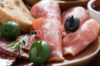 assorted Italian antipasti - meats, olives and ciabatta, closeup