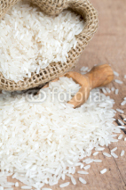 Naklejki rice in a burlap bag on wooden surface