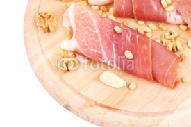 Naklejki Composition of prosciutto on wooden platter.