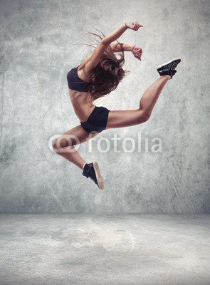 young woman dancer with grunge wall background