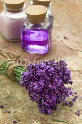 Bouquet of fresh purple flowers and bottles of soap and lotion