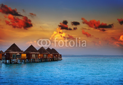houses on piles on water at the time sunset