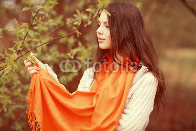 young girl in an orange scarf on a walk in the park