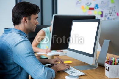 Male graphic designer using graphics tablet at desk