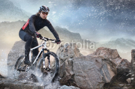 Fototapety Cyclist climbing on a rock