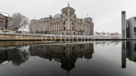 Berlin, Germany Winter The Reichstag is reflected in the cold waters of the Spree.
