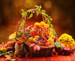 Naklejki Wicker basket with autumn fruits and flowers