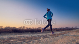 Obrazy i plakaty ragazza atletica si allena all'aperto su terra di sera