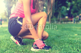 Naklejki Close-up of active jogging female runner, preparing shoes