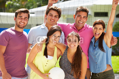 Group Of Friends Playing Volleyball In Garden