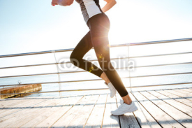 Fototapety Cropped image of a runner woman feet in action