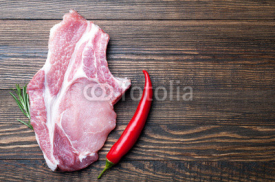 Naklejki Raw fresh meat ribeye steak with herb rosemary and pepper on a dark wooden background with copy space. Ingredient for cooking