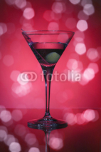 Fototapety wineglass with martini and olives on red background.