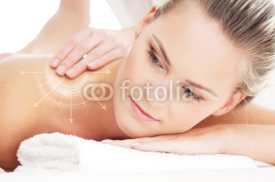 Naklejki A young and beautiful woman on a back massage procedure