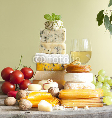Pile of cheese many various types with wine grapes and nuts