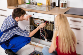Technician Checking Dishwasher In Kitchen
