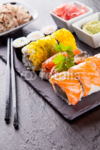 Naklejki Delicious sushi pieces served on black stone