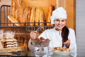 Portrait of friendly  young woman at bakery display