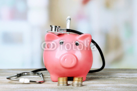 Naklejki Pink piggy bank with stethoscope on light background