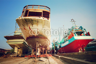 Fishing boats in a shipyard for maintenance.